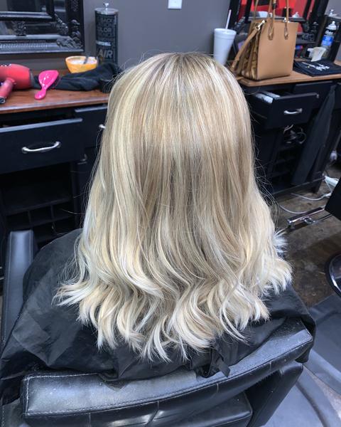 Long blonde highlights with soft waves, seen from the back