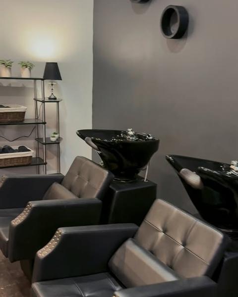 Two black shampoo chairs and bowls in the salon